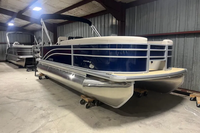 Slide: The Image of 2026 Harris Cruiser 210 FC pontoon boat in a storage facility. - 2
