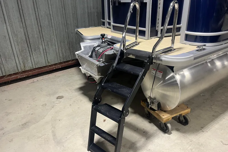 Slide: The Image of 2026 Harris Cruiser 210 FC pontoon boat with ladder in a garage setting. - 10