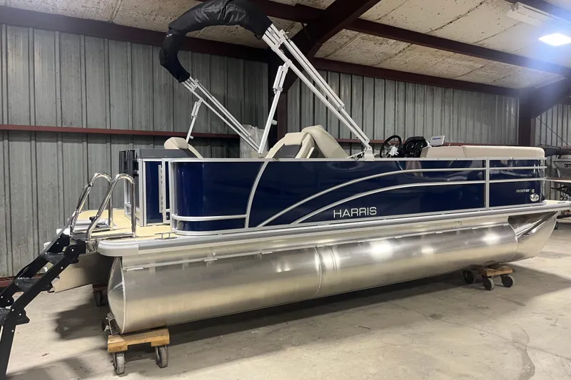 Slide: The Image of 2026 Harris Cruiser 210 FC pontoon boat in a warehouse, featuring sleek blue design. - 9