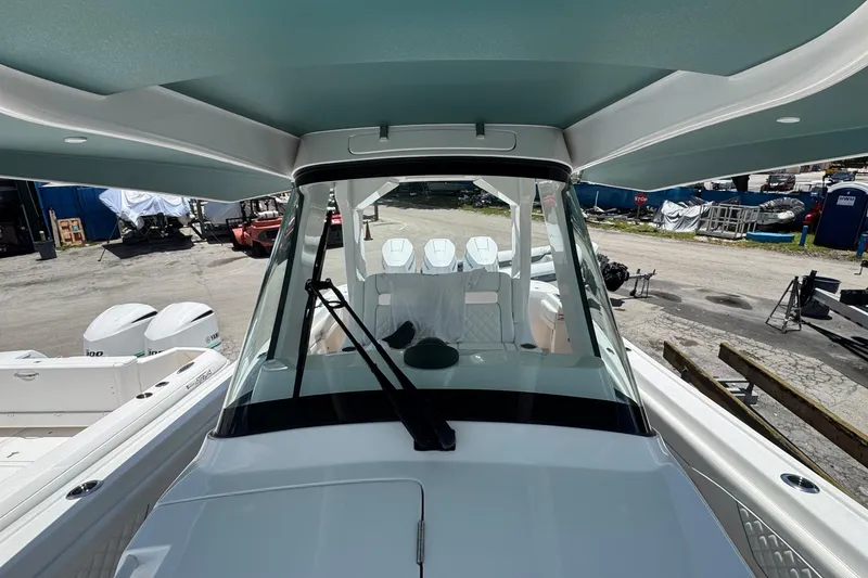 Slide: The Image of 2025 Intrepid 375 Nomad SE boat with sleek design and powerful engines at a marina. - 11