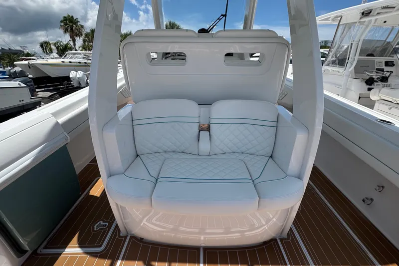 Slide: The Image of 2025 Intrepid 375 Nomad SE boat interior with luxurious white seating and teak flooring. - 14