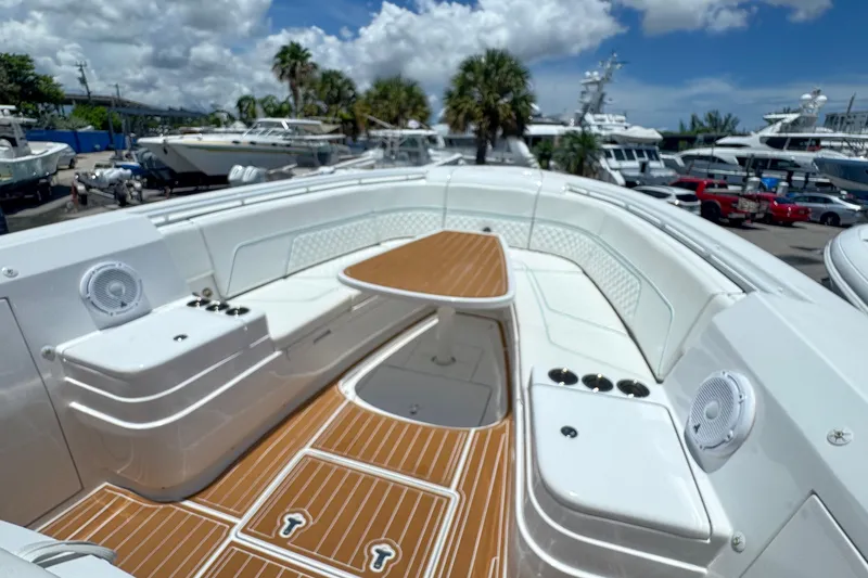 Slide: The Image of 2025 Intrepid 375 Nomad SE boat with spacious seating and sleek design in marina setting. - 5