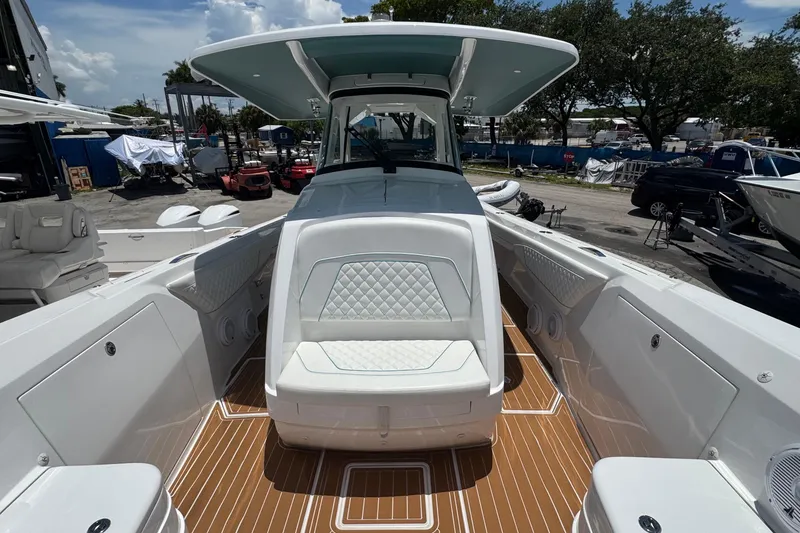 Slide: The Image of 2025 Intrepid 375 Nomad SE boat interior with cushioned seating and teak flooring. - 9