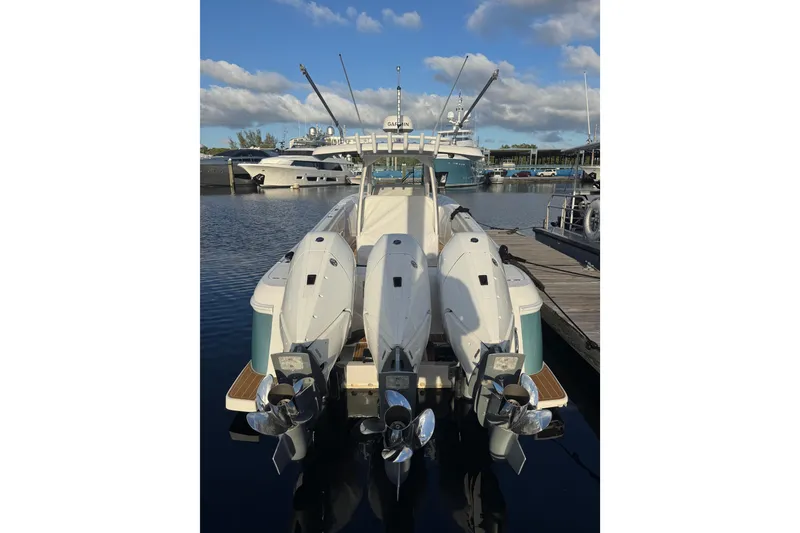 Slide: The Image of 2025 Intrepid 375 Nomad SE boat with triple outboard engines docked at marina. - 38