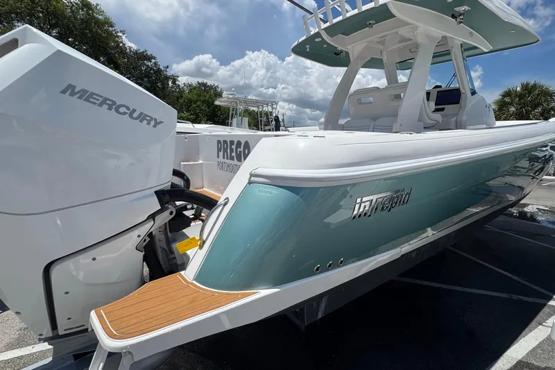 Slide: The Image of 2025 Intrepid 375 Nomad SE boat with Mercury engine, docked under a sunny sky. - 4