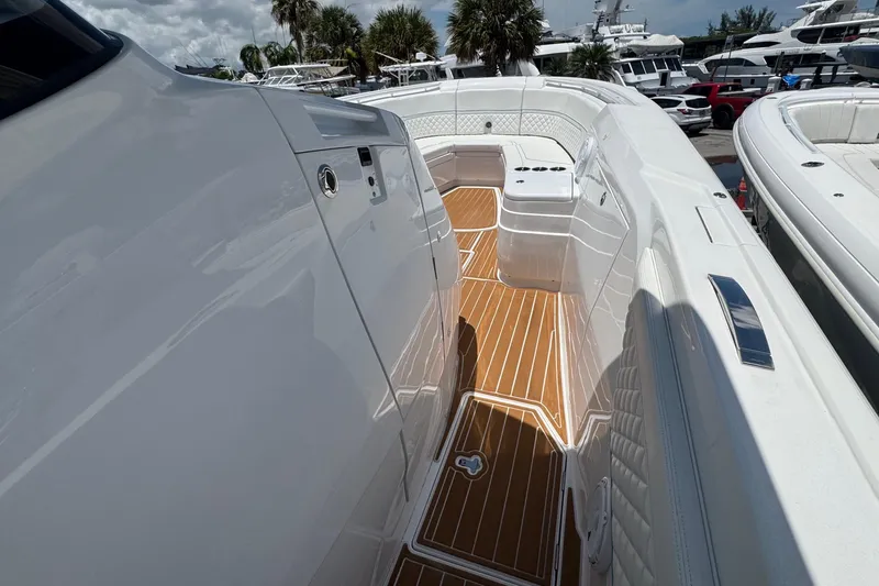 Slide: The Image of 2025 Intrepid 375 Nomad SE boat deck with sleek white design and wood accents. - 31