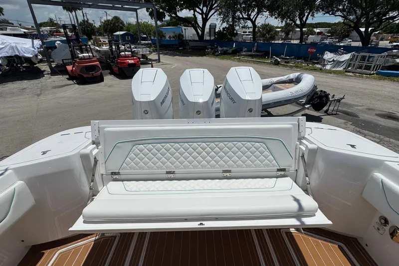 Slide: The Image of 2025 Intrepid 375 Nomad SE boat with triple Mercury engines and cushioned seating. - 13