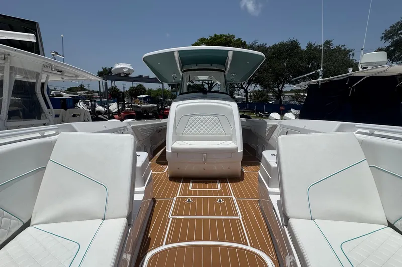 Slide: The Image of 2025 Intrepid 375 Nomad SE boat interior with white seating and teak flooring. - 8