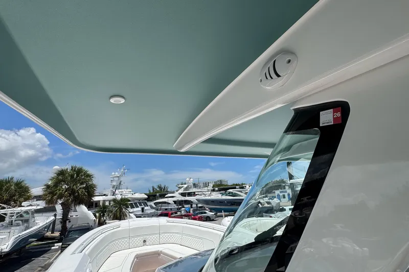 Slide: The Image of 2025 Intrepid 375 Nomad SE boat with sleek design, docked under clear blue sky. - 34