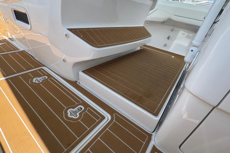 Slide: The Image of 2025 Intrepid 375 Nomad SE boat deck with teak-style flooring and white accents. - 27