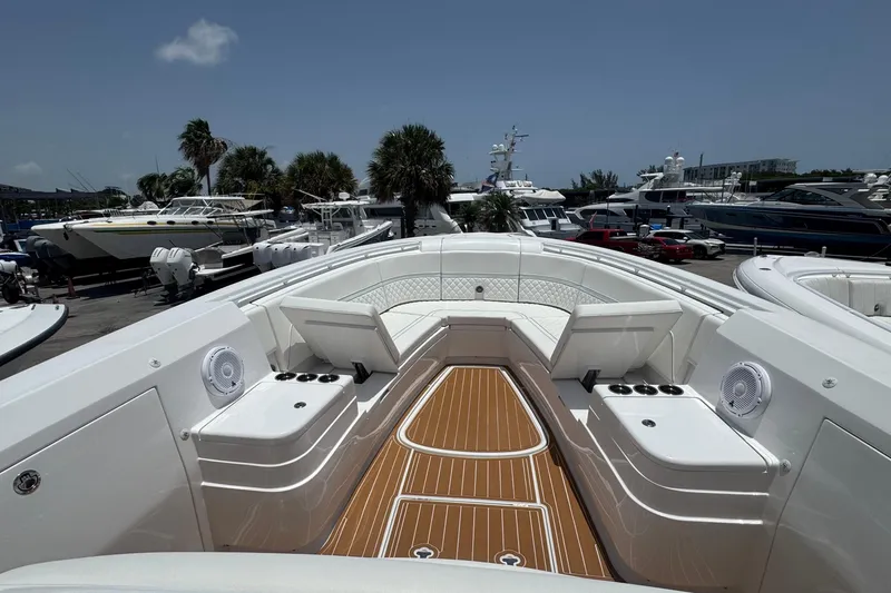 Slide: The Image of 2025 Intrepid 375 Nomad SE boat with luxurious seating and teak flooring at a marina. - 6
