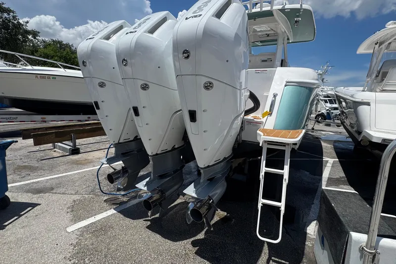 Slide: The Image of 2025 Intrepid 375 Nomad SE with triple outboard engines in a marina setting. - 20