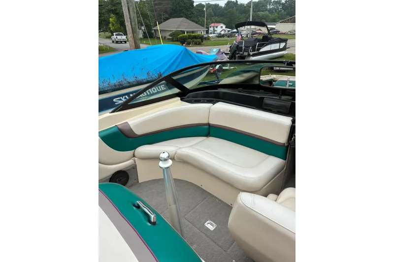 Slide: The Image of 1996 MasterCraft ProStar 190 interior with white and teal seating, parked outdoors. - 6