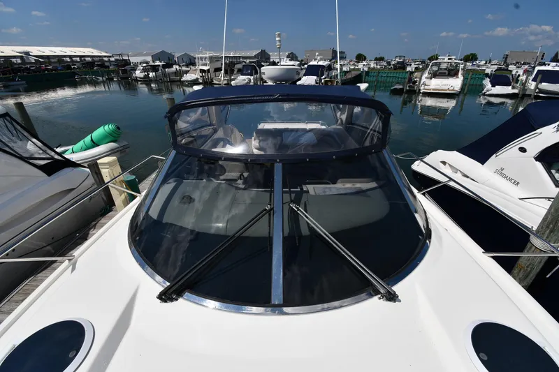 Slide: The Image of 1997 Sunseeker Camargue 51 yacht docked at marina, showcasing sleek design and windshield. - 10
