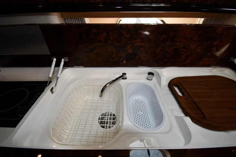 Slide: The Image of Kitchen sink area in 1997 Sunseeker Camargue 51 yacht with cutting board and colander. - 53
