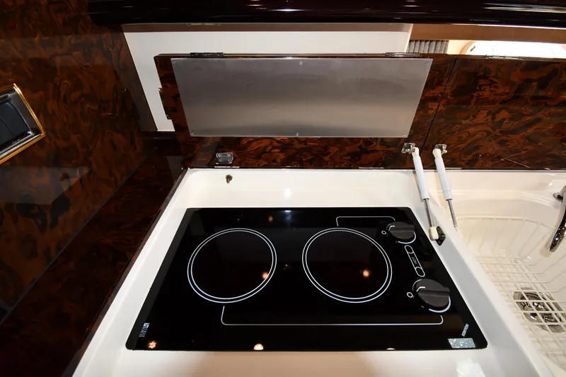 Slide: The Image of 1997 Sunseeker Camargue 51 yacht kitchen with modern stovetop and elegant wood finish. - 54