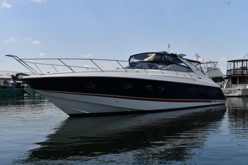 Slide: The Image of 1997 Sunseeker Camargue 51 yacht docked in a marina under a clear sky. - 1
