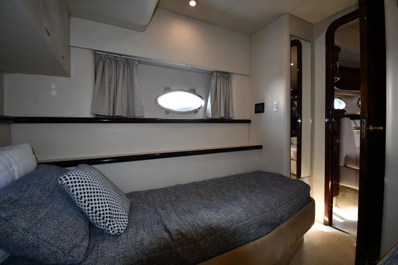 Slide: The Image of Interior cabin of 1997 Sunseeker Camargue 51 yacht, featuring a cozy bed and porthole window. - 48