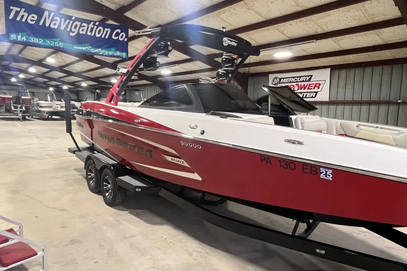 Slide: The Image of 2015 Malibu Wakesetter 24 MXZ boat in showroom, red and white exterior, on trailer. - 2
