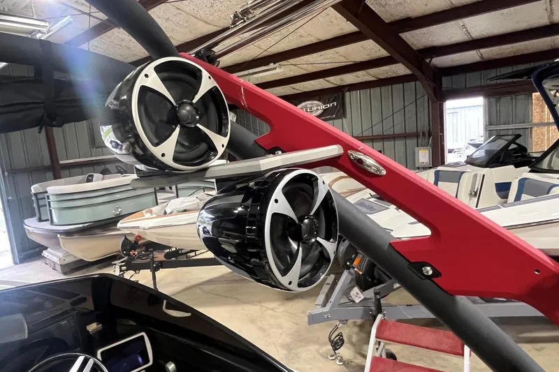 Slide: The Image of 2015 Malibu Wakesetter 24 MXZ with tower speakers in a boat storage facility. - 9