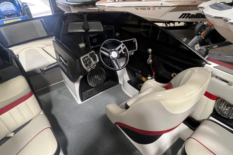 Slide: The Image of Interior of a 2015 Malibu Wakesetter 24 MXZ boat, featuring sleek seating and modern controls. - 6