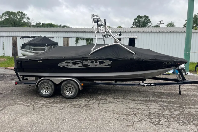 Slide: The Image of 2004 MasterCraft X-9 boat on trailer, covered, parked outdoors. - 8
