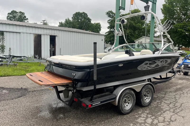 Slide: The Image of 2004 MasterCraft X-9 boat on trailer, black with custom graphics, parked outdoors. - 6