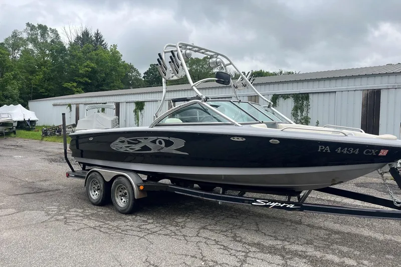 Slide: The Image of 2004 MasterCraft X-9 boat on trailer, parked outdoors near storage buildings. - 5