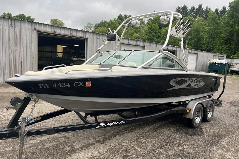 Slide: The Image of 2004 MasterCraft X-9 boat on trailer, parked outdoors near a metal building. - 7