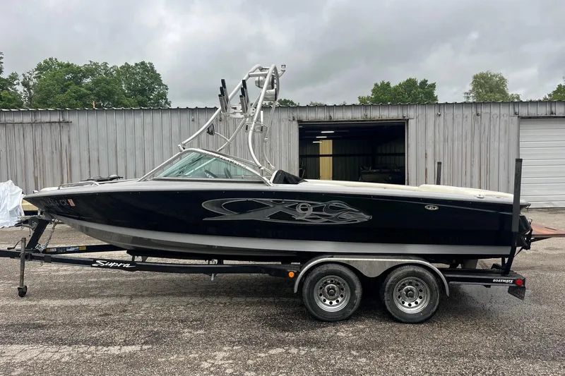 The Image of 2004 MasterCraft X-9 boat on trailer, parked outside a metal building. - 1