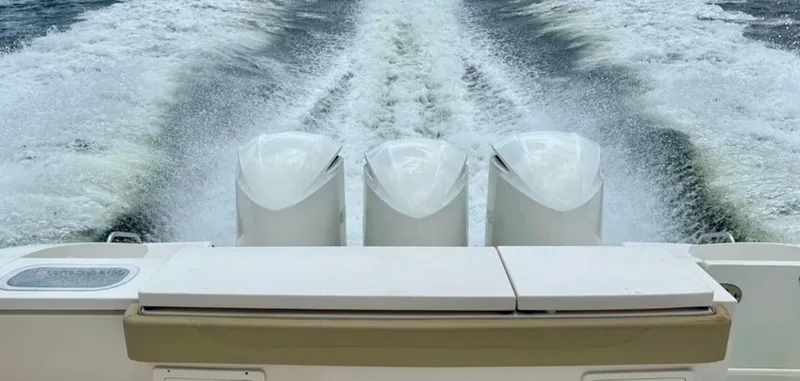 Slide: The Image of Three powerful outboard engines propel the boat across the water, leaving a splashing wake. - 1
