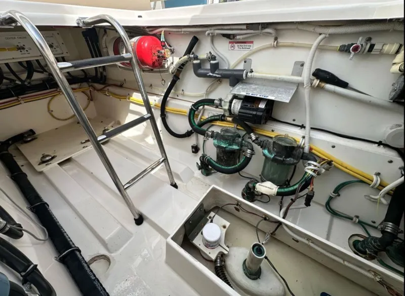 Slide: The Image of The engine room of a 2017 Pursuit S 408 Sport with ladders and various hoses. - 4