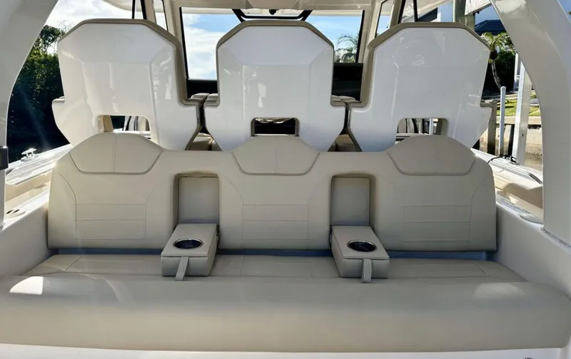 Slide: The Image of The rear seating of a 2017 Pursuit S 408 Sport with built-in cup holders. - 2