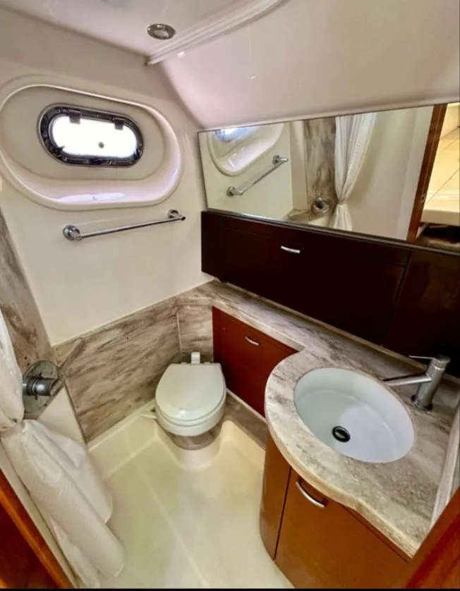 Slide: The Image of The image shows an elegant boat bathroom with a sink, toilet, and porthole. - 7