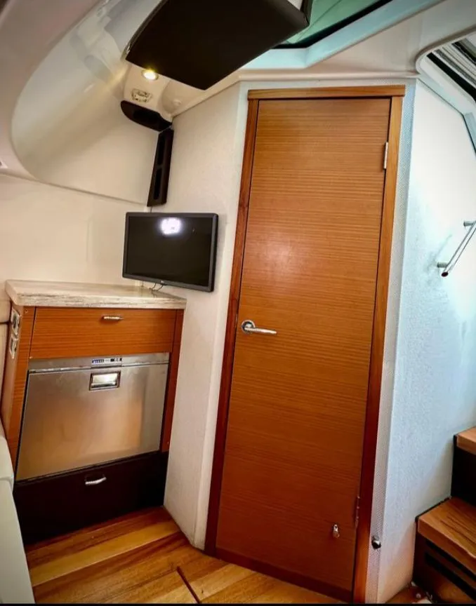 Slide: The Image of Interior of a 2017 Pursuit S 408 Sport with wooden doors and a small TV. - 6