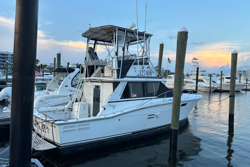 Slide: The Image of 1979 Trojan F-36 Convertible boat docked at marina during sunset. - 2