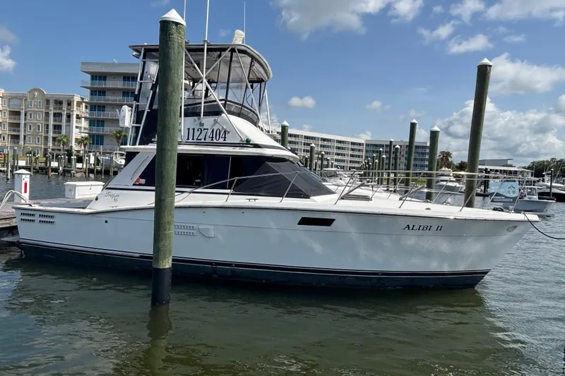 Slide: The Image of 1979 Trojan F-36 Convertible boat docked at marina under blue sky. - 15