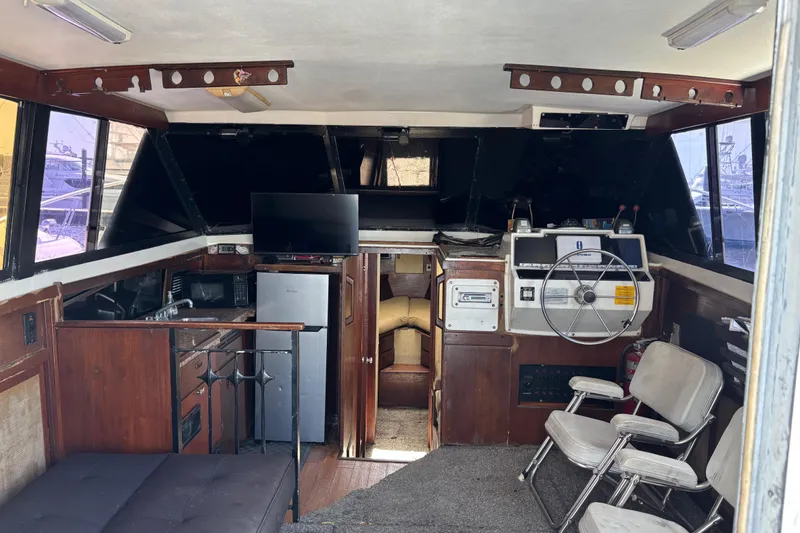 Slide: The Image of Interior of a 1979 Trojan F-36 Convertible boat with helm, seating, and kitchenette. - 19