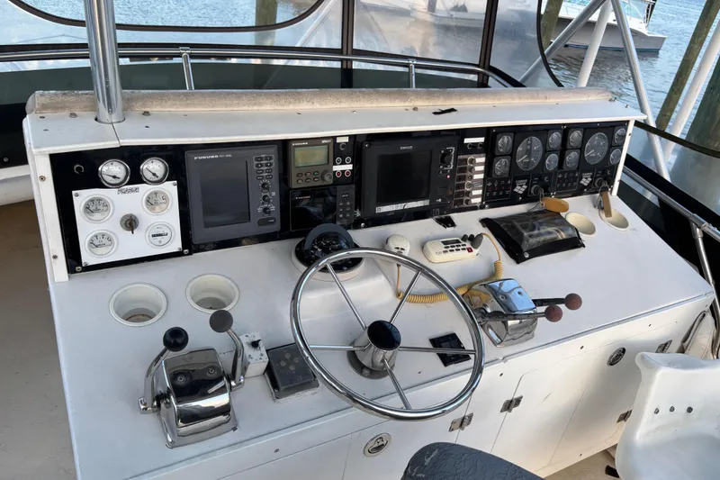 Slide: The Image of 1979 Trojan F-36 Convertible boat helm with gauges, steering wheel, and navigation equipment. - 6