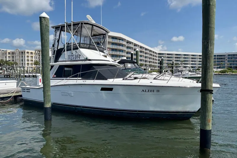Slide: The Image of 1979 Trojan F-36 Convertible boat named "ALIBI II" docked at a marina. - 1