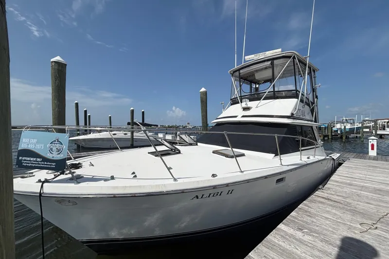 The Image of 1979 Trojan F-36 Convertible yacht docked at marina under clear blue sky. - 0
