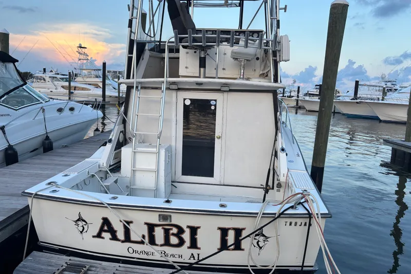 Slide: The Image of 1979 Trojan F-36 Convertible boat docked at marina, labeled "Alibi II," Orange Beach, AL. - 4