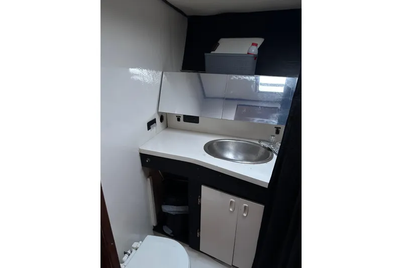 Slide: The Image of 1979 Trojan F-36 Convertible bathroom with sink, mirror, and storage cabinet. - 16