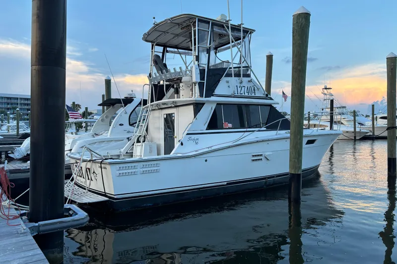 Slide: The Image of 1979 Trojan F-36 Convertible boat docked at marina during sunset. - 5