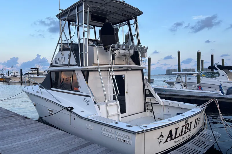 Slide: The Image of 1979 Trojan F-36 Convertible boat docked at marina, evening sky in background. - 3