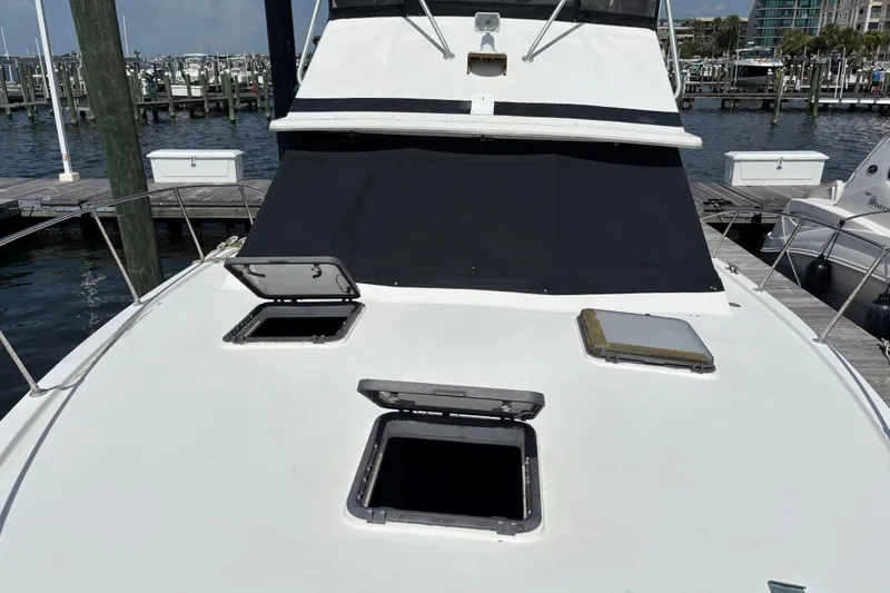 Slide: The Image of 1979 Trojan F-36 Convertible boat docked, featuring open hatches and marina background. - 11