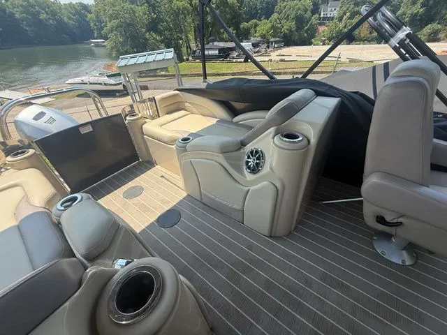 Slide: The Image of The image shows the interior of a 2017 Starcraft MX 23 C boat with beige seating and cup holders. - 23