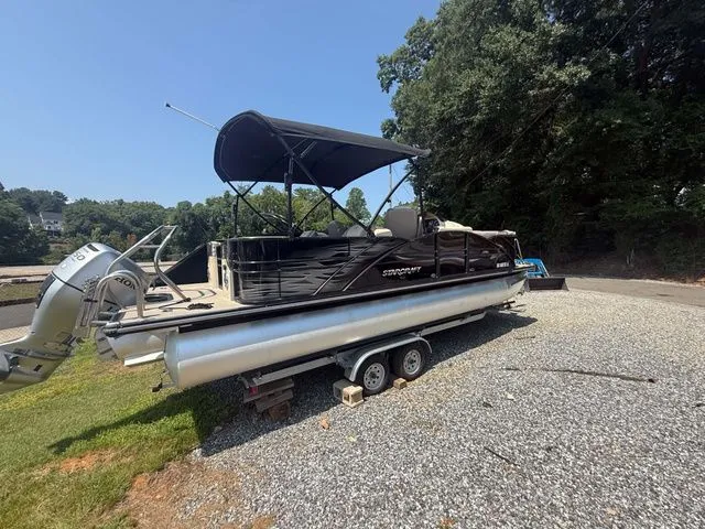 Slide: The Image of A 2017 Starcraft MX 23 C pontoon boat on a trailer in a gravel area. - 7
