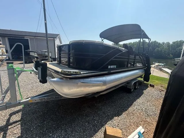Slide: The Image of A black Starcraft MX 23 C pontoon boat is on a trailer on land. - 8