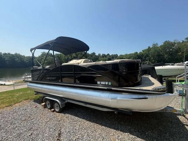 Slide: The Image of A black 2017 Starcraft MX 23 C pontoon boat on a trailer by the shore. - 6